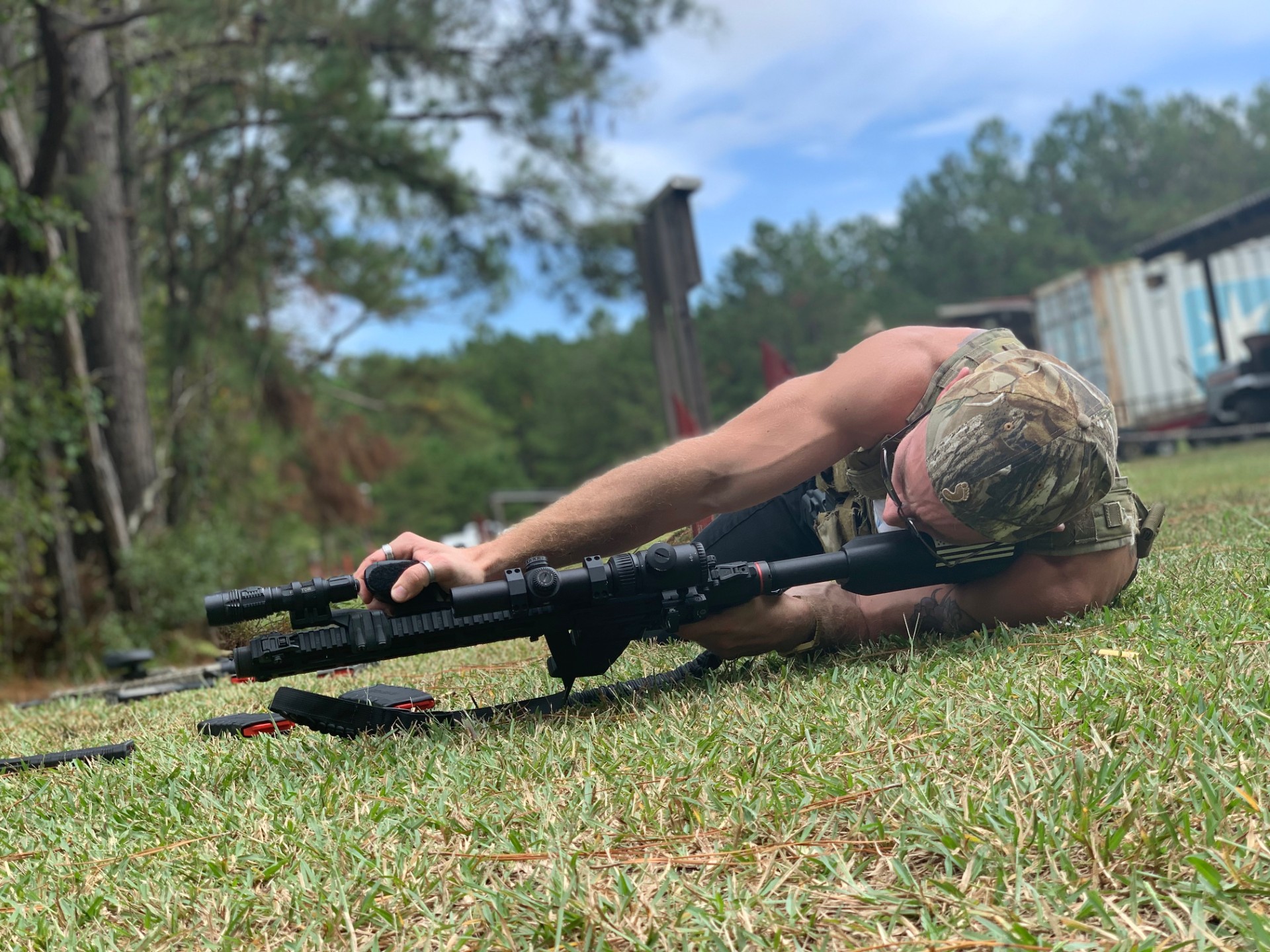 Joey LeBlanc in prone position aiming a suppressed rifle during range practice.